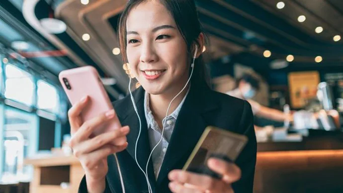 Young woman making a payment with her phone