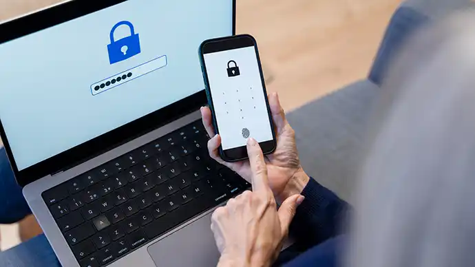 Protecting Your Online Accounts: Password Safety Tips person entering encrypted passwords on a phone and laptop