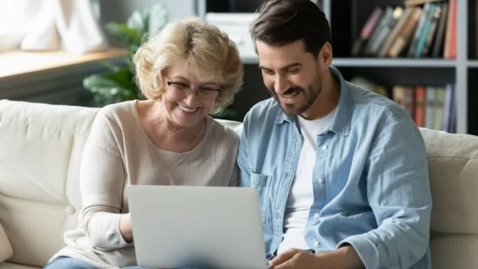 Son looking over finances on a laptop with his mother